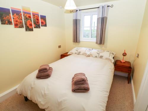 a bedroom with a white bed with towels on it at Carrington Cottage in Lincoln