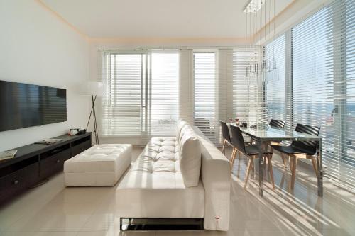 a living room with a white couch and a table at Stunning Apt w/ Balcony & Sea View by Sea N' Rent in Tel Aviv