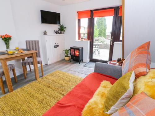 a living room with a couch and a table at Bwlch Y Gwynt Bach in Llangefni