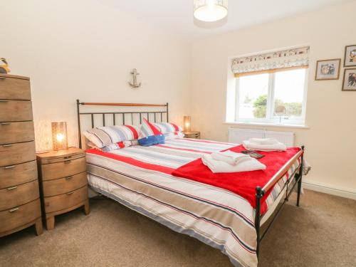 a bedroom with a large bed and a window at Tides Reach in Rhosneigr
