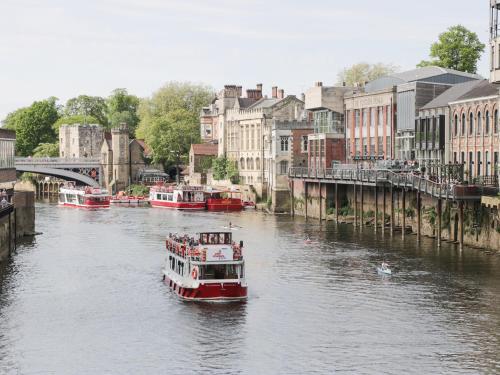 a boat traveling down a river in a city at The Stable in York
