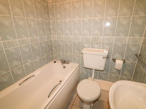 La salle de bains est pourvue de toilettes, d'une baignoire et d'un lavabo. dans l'établissement Apartment 42, à Bundoran