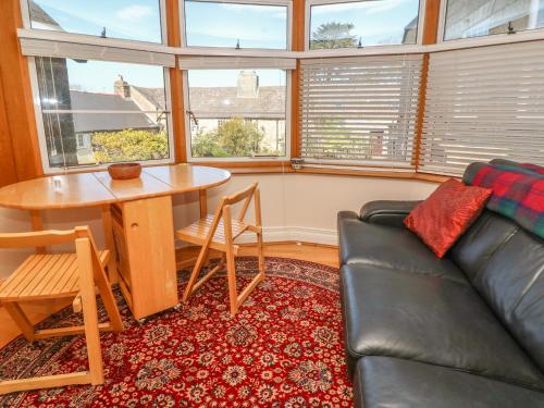 a living room with a couch and a table at Surf Song in Penzance