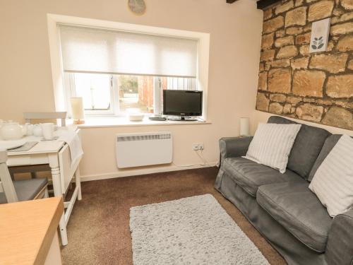 a living room with a couch and a table at Wren Cottage in Morpeth