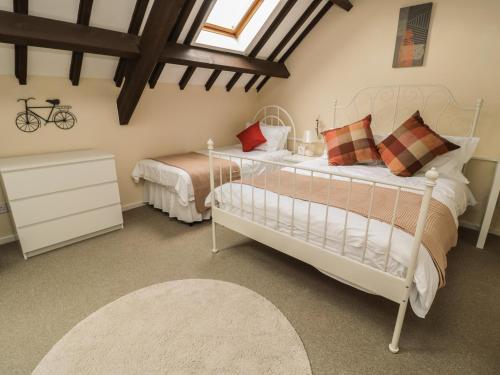 a bedroom with a white bed and a white dresser at Heron Cottage in Morpeth