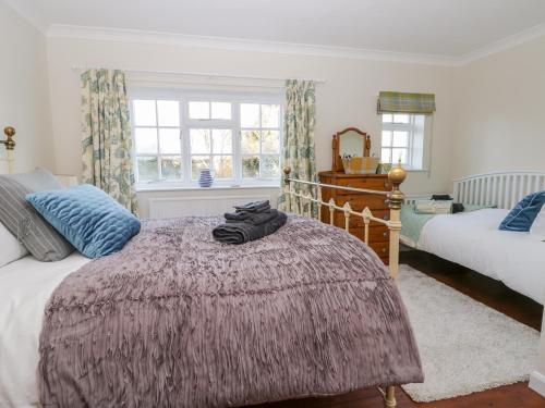 a bedroom with a bed with a purple blanket at Pelham House Cottage in Market Rasen