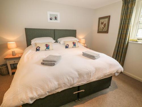 a bedroom with a large bed with towels on it at The Old Stables in Minehead