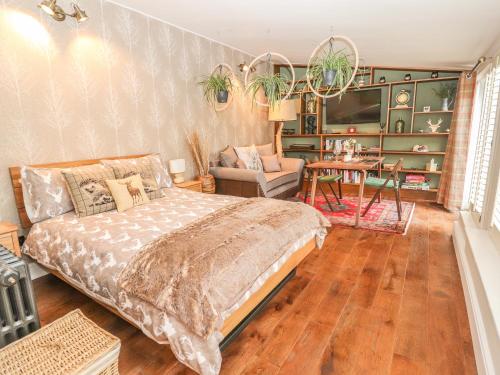ein Schlafzimmer mit einem Bett und ein Wohnzimmer in der Unterkunft The Cottage The Coach House in Wrexham
