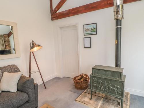 a living room with a stove and a couch at The Byre in Stockton-on-Tees