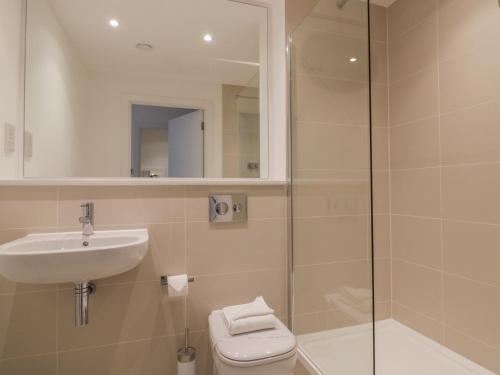 a bathroom with a toilet and a sink and a shower at Chapel Rock View, The Dunes in Perranporth