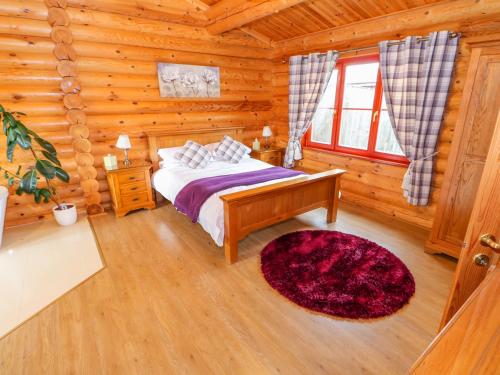 a bedroom with a bed in a log cabin at Beech Lodge in Oakham