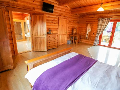 Beech Lodge في أوكهام: غرفة نوم بسرير في كابينة خشبية