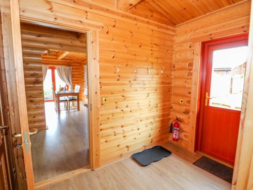 a log cabin with a red door and a dining room at Beech Lodge in Oakham