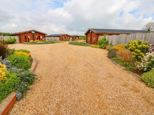 a gravel driveway leading to a home with houses at Beech Lodge in Oakham