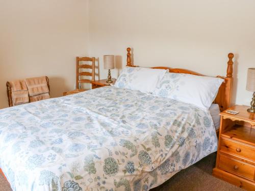 a bedroom with a bed with a blue and white blanket at The Barn in Skipton