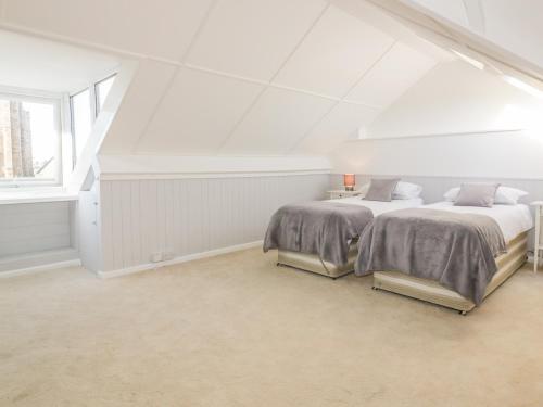 a attic bedroom with two beds and a window at Chy-an-Brae in Newquay