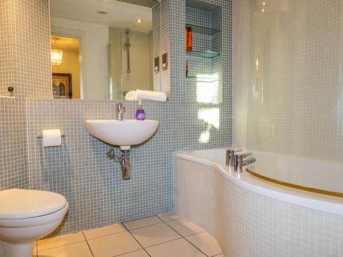 uma casa de banho com um lavatório, uma banheira e um WC. em The Orangery em Turriff