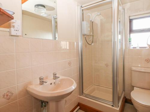 a bathroom with a sink and a shower at Cordwainer Cottage in Stoke on Trent