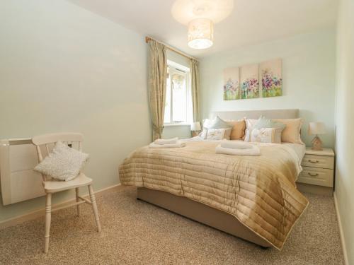 a bedroom with a bed and a chair and a window at Bearscombe in Ivybridge