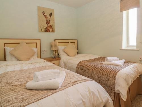 a bedroom with two beds with white towels on them at Bearscombe in Ivybridge