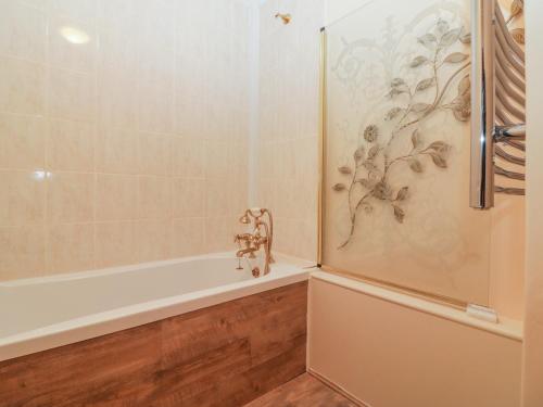 a bathroom with a shower and a tub at Bearscombe in Ivybridge