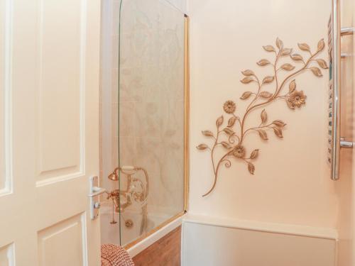 a shower stall with a floral design on the wall at Bearscombe in Ivybridge