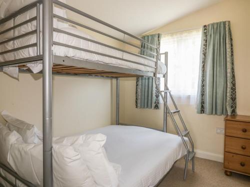 a bedroom with two bunk beds and a window at Chalet 186 in Padstow