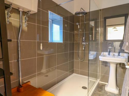 a bathroom with a shower and a sink at Crooked Hill Cottage in Ammanford