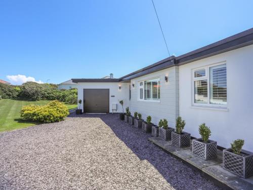 a white house with a driveway at Gadlys in Trearddur