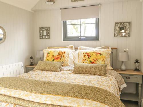 a bedroom with a bed with pillows and a window at High Rigg Shepherd's Delight in Brampton