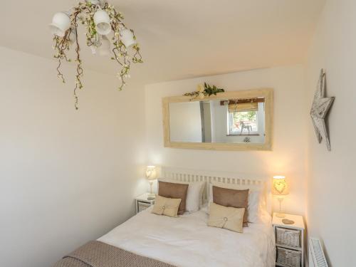 1 dormitorio con 1 cama con espejo y 2 lámparas en Hen Gilfach Stable, en Llanrhwydrys