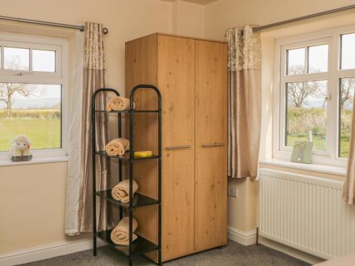 une chambre avec une armoire en bois à côté d'une fenêtre dans l'établissement Derwent House Farm, à Malton