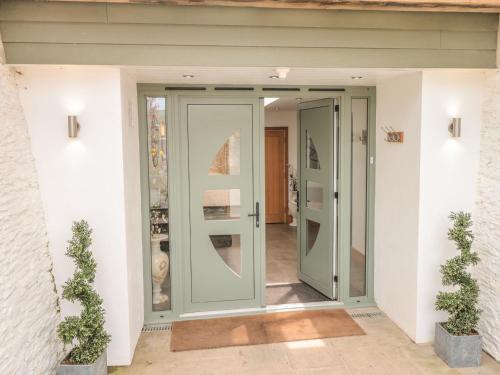 a glass door leading into a house with aoyer at Lower Norton Farmhouse in Dartmouth