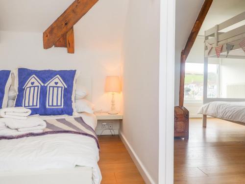 a bedroom with a bed with a blue pillow at The Loft at Beach House in St Austell