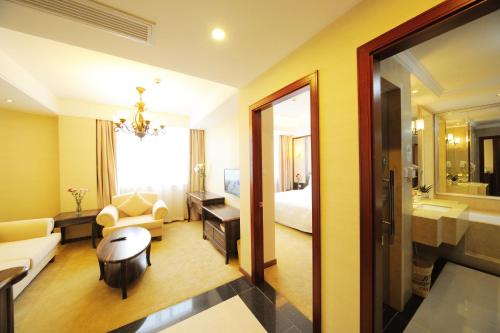 een hotelkamer met een slaapkamer en een woonkamer bij Greentree Inn Shanghai West Huaxia Road Metro Station Express Hotel in Shanghai