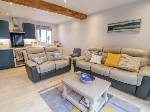 a living room with two couches and a table at 7evern Porth Farm in Caersws
