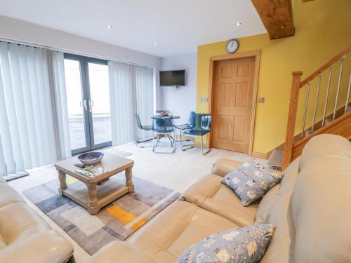 a living room with a couch and a table at 7evern Porth Farm in Caersws