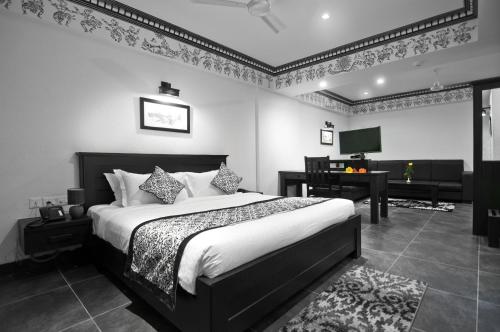 a bedroom with a bed and a desk and a television at Liwa - The Transit Hotel, Bengaluru in Bengaluru