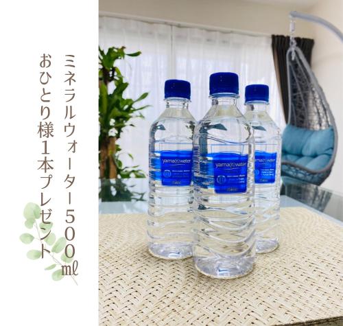 three bottles of water sitting on a table at HOTEL FIT IN ISHIGAKIJIMA 新築2021年4月OPEN セキュリティ万全 セルフチェックイン -SEVEN Hotels and Resorts- in Ishigaki Island