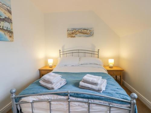 a bedroom with a bed with towels on it at Bayside Cottage in Filey