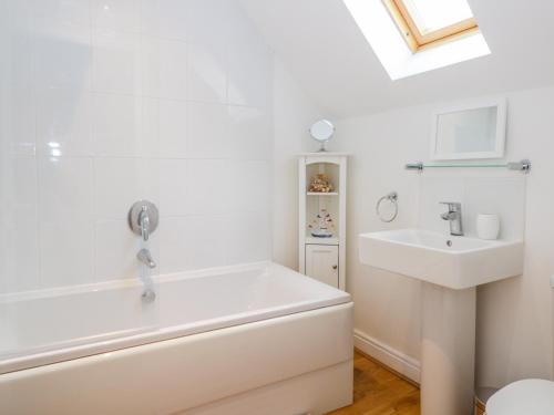 a bathroom with a white tub and a sink at Bayside Cottage in Filey