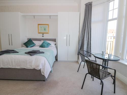 a bedroom with a bed and a glass table at Southpoint in Bridlington
