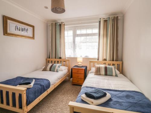 a bedroom with two beds and a window at Ducks Ditty in Liskeard