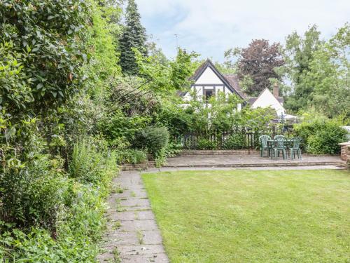 a garden with chairs and a house in the background at Bridge View Cottage in Telford