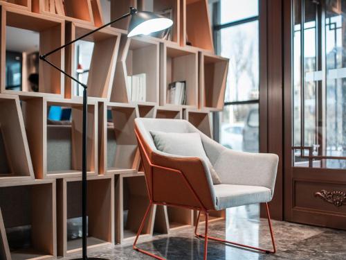 a lamp and a chair in a room with shelves at Holiday Inn Express Changchun Jingyue by IHG in Changchun