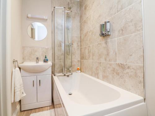 a bathroom with a shower and a tub and a sink at SeaSound in Ilfracombe
