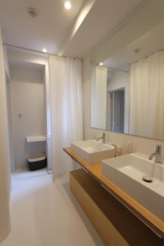 een badkamer met 2 wastafels en een spiegel bij Nebou Hotel in Osaka