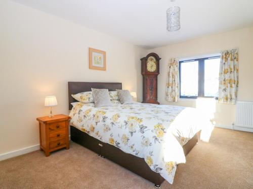 a bedroom with a bed with a clock on the wall at 6 Aonachan Gardens in Spean Bridge