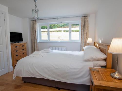 een slaapkamer met een wit bed en een raam bij 1 Lyndhurst in Salcombe