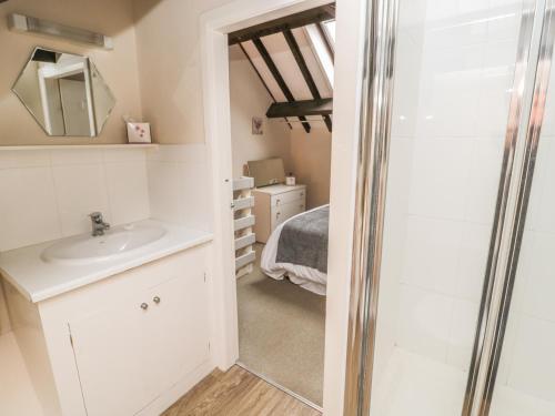 une salle de bain avec un lavabo et un miroir dans l'établissement Robin Cottage, à Morpeth